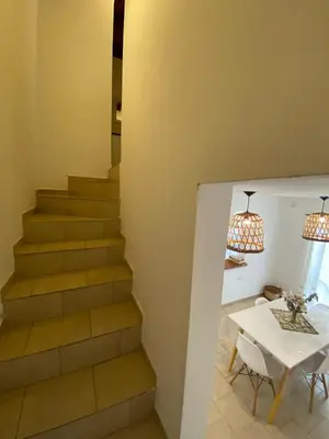 a stairway with a white table and a white table and chairs at Complejo Arenas in Alta Gracia