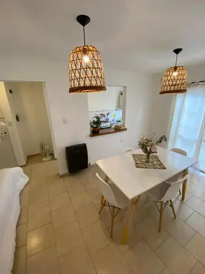 a dining room with a white table and chairs at Complejo Arenas in Alta Gracia