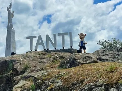 a person standing in front of a sign on top of a mountain at La Loma del Valle in Tanti