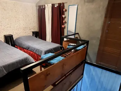 a bedroom with two beds and a mirror at La Loma del Valle in Tanti