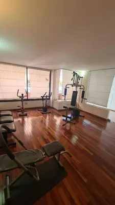a gym with several treadmills and chairs on a wooden floor at Escaparte nunca se sintió tan bien, este es tu rincón para disfrutar in Villa Carlos Paz