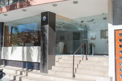 a glass building with stairs in front of it at Escaparte nunca se sintió tan bien, este es tu rincón para disfrutar in Villa Carlos Paz