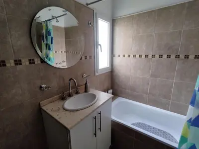 a bathroom with a sink and a tub and a mirror at Departamento Alta Cordoba Lautaro II Dormitorios con Pileta in Cordoba