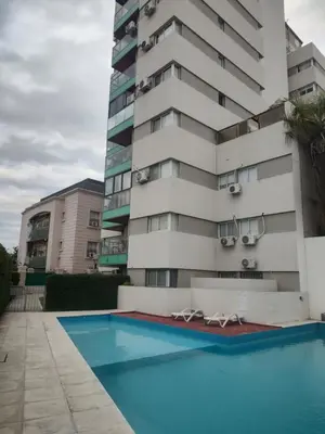 a building with a swimming pool in front of a building at Departamento Alta Cordoba Lautaro II Dormitorios con Pileta in Cordoba