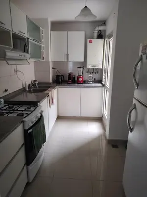 a kitchen with white cabinets and a stove top oven at Departamento Alta Cordoba Lautaro II Dormitorios con Pileta in Cordoba