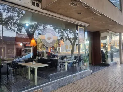 a window of a restaurant with tables and chairs at Departamento Alta Cordoba Lautaro II Dormitorios con Pileta in Cordoba