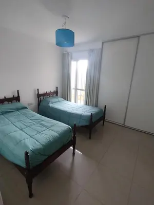 two beds in a room with a window at Departamento Alta Cordoba Lautaro II Dormitorios con Pileta in Cordoba