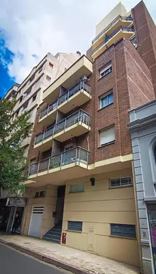 a tall brick building with balconies on a street at Departamento SANATORIO ALLENDE - OULTON - GÜEMES - CENTRO - 5 MIN HOSPITAL PRIVADO - QUALITY - CÓRDOBA in Cordoba