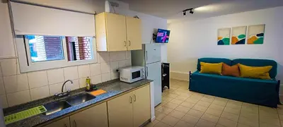 a kitchen with a blue couch in a room at Departamento SANATORIO ALLENDE - OULTON - GÜEMES - CENTRO - 5 MIN HOSPITAL PRIVADO - QUALITY - CÓRDOBA in Cordoba