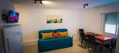 a living room with a blue couch and a table at Departamento SANATORIO ALLENDE - OULTON - GÜEMES - CENTRO - 5 MIN HOSPITAL PRIVADO - QUALITY - CÓRDOBA in Cordoba
