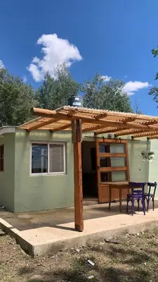 a house with a wooden roof and a table and a ladder at Espejo Escondido in Tanti