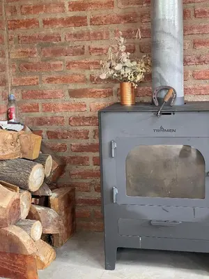 a brick wall with a wood stove in a room at Tila Huasi in Villa Icho Cruz