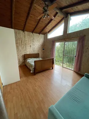 a bedroom with a bed and a large window at Tila Huasi in Villa Icho Cruz