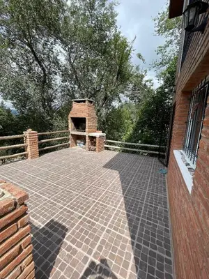 a brick patio with a brick fireplace on a house at Tila Huasi in Villa Icho Cruz