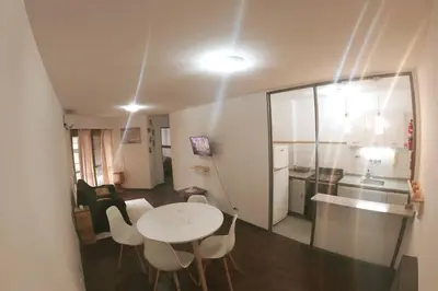 a room with a table and chairs and a kitchen at Depto. Lindo Excelente Ubicación in Cordoba