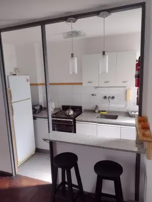 a kitchen with a counter and two stools at Depto. Lindo Excelente Ubicación in Cordoba