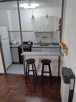 a kitchen with a counter and two stools in it at Depto. Lindo Excelente Ubicación in Cordoba