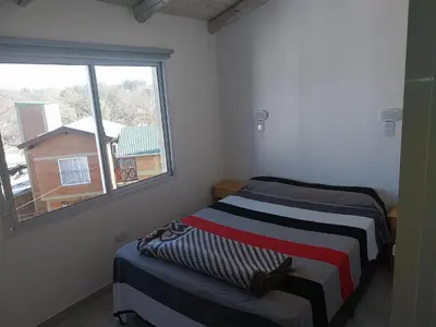 a room with two beds and a window at Talamochita in Santa Rosa de Calamuchita