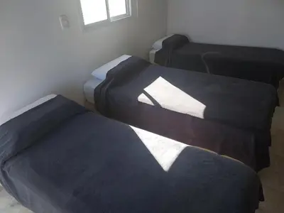 three beds sitting in a room with a window at Talamochita in Santa Rosa de Calamuchita
