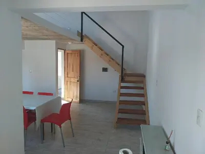 a staircase in a room with a table and chairs at Talamochita in Santa Rosa de Calamuchita