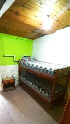 a room with a bed with a green wall at Dpto en Santa María de Punilla in Cordoba