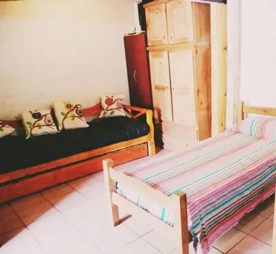 a room with two beds and a door in it at Dpto en Santa María de Punilla in Cordoba