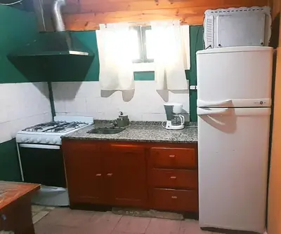 a small kitchen with a refrigerator and a stove at Dpto en Santa María de Punilla in Cordoba