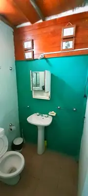 a bathroom with a white toilet and a sink at Dpto en Santa María de Punilla in Cordoba