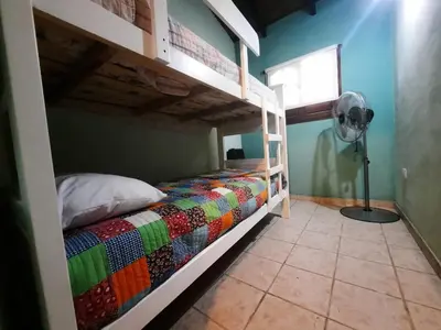a bedroom with a bunk bed with a colorful blanket at Cabaña Kiara VGB in Villa General Belgrano