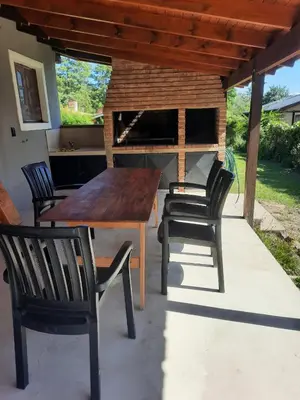 a wooden table and chairs on a patio at Cabaña Kiara VGB in Villa General Belgrano