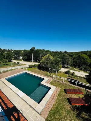 a swimming pool in a yard with chairs around it at La Chuña in Villa Los Aromos