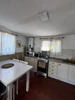 a kitchen with a table and a stove top oven at La Chuña in Villa Los Aromos