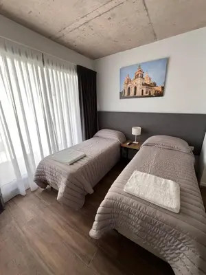 a bedroom with two beds and a large window at Departamentos en Barrio Gral Paz a pocos metros de clínicas in Cordoba