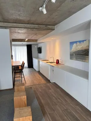 a kitchen with white cabinets and a table and a dining room at Departamentos en Barrio Gral Paz a pocos metros de clínicas in Cordoba