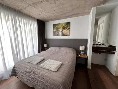 a bedroom with a large bed and a sink at Departamentos en Barrio Gral Paz a pocos metros de clínicas in Cordoba