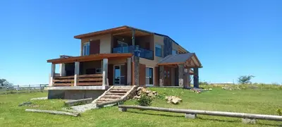 a house on top of a grassy field at Las Calandrias in La Cumbrecita