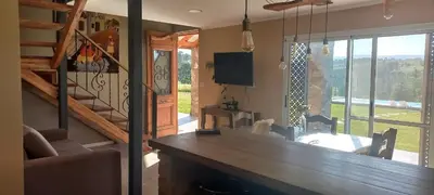 a living room with a wooden counter and a staircase at Las Calandrias in La Cumbrecita