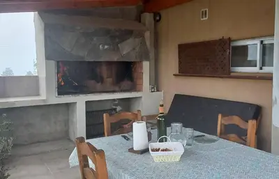 a table with a bottle of wine and a fireplace at Las Calandrias in La Cumbrecita