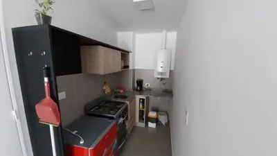 a small kitchen with a red and black stove top oven at Hermoso en Plaza Alberdi in Cordoba