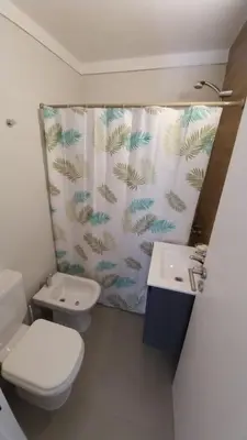 a bathroom with a toilet and a sink and a shower curtain at Hermoso en Plaza Alberdi in Cordoba