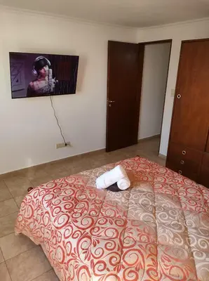 a bedroom with a bed with a tv on the wall at Departamento céntrico in Río Cuarto