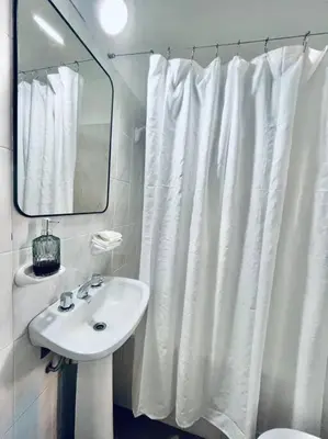 a bathroom with a white shower curtain and a sink at Nueva Cordoba a metros de Palacio Ferreyra in Cordoba