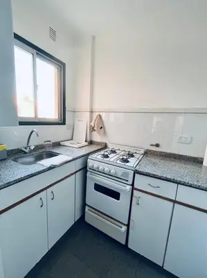 a white kitchen with a stove and a sink at Nueva Cordoba a metros de Palacio Ferreyra in Cordoba