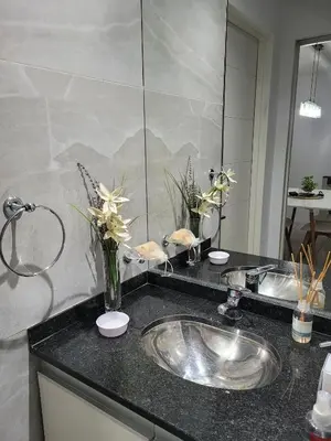 a bathroom sink with a vase of flowers on a counter at Departamento Nueva Cordoba in Cordoba