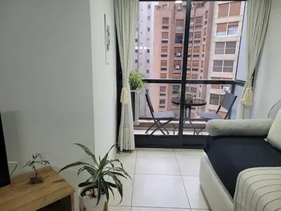 a living room with a couch and a balcony at Departamento Nueva Cordoba in Cordoba