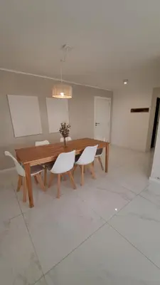 a dining room with a wooden table and white chairs at Apartamento -Diva- Complejo 