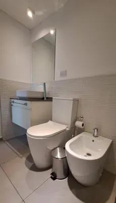 a bathroom with a white toilet and a mirror at Apartamento -Diva- Complejo 