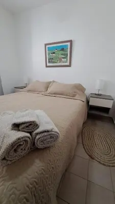 a bed with a blanket and a picture on the wall at Apartamento -Alberdi Chic B- Barrio cercanos Nueva Córdoba, Güemes, Alberdi, By Apartcba in Cordoba