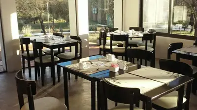 a dining room with tables and chairs and windows at Zahrek Resorts & SPA in San Javier