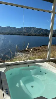 a bath tub in a room with a view of the water at Veneto Village Resort & Spa in Villa Carlos Paz